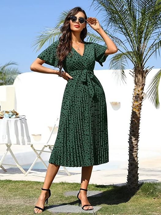 A model wearing the green and black polka dot dress