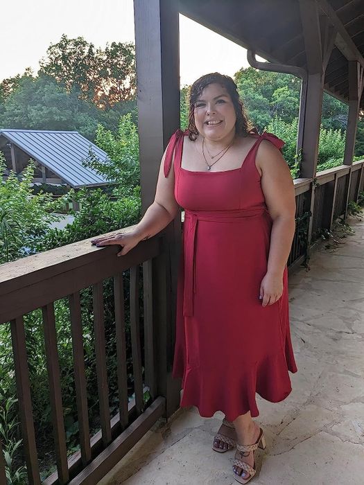 A reviewer in the burgundy long dress, praising its elegant design, flattering fit, and versatility for formal occasions.