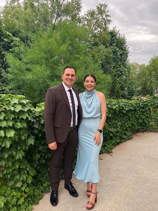 A reviewer in the light blue satin dress, sharing their experience and thoughts on the fit and style.