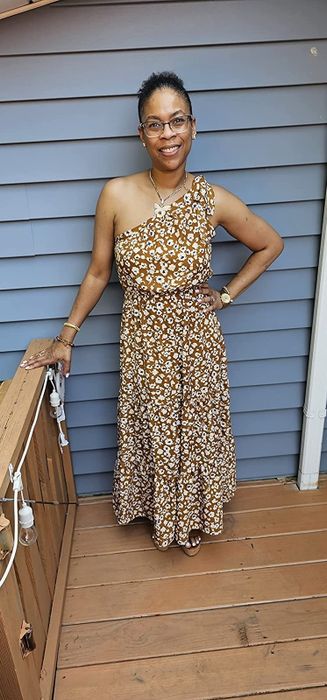 A reviewer in the mustard floral maxi, sharing their experience with its comfort, fit, and suitability for warm-weather events.