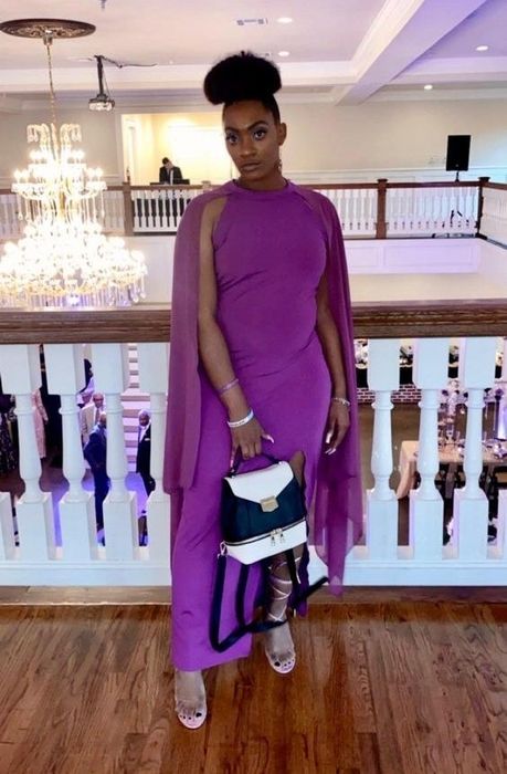 reviewer in a sleeveless maxi dress with a floor-length cape in vibrant purple