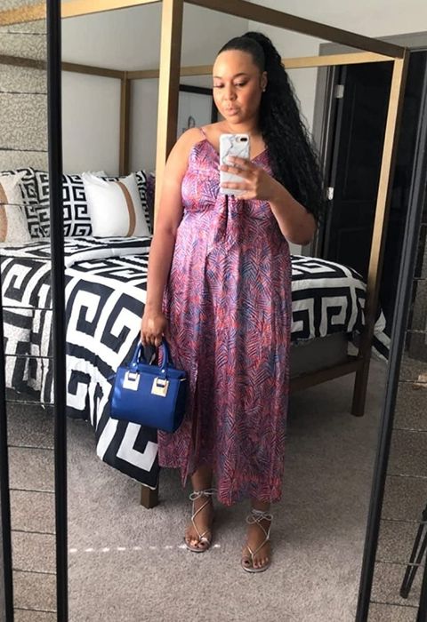 A reviewer showcasing the same dress in a blue and pink leaf print design