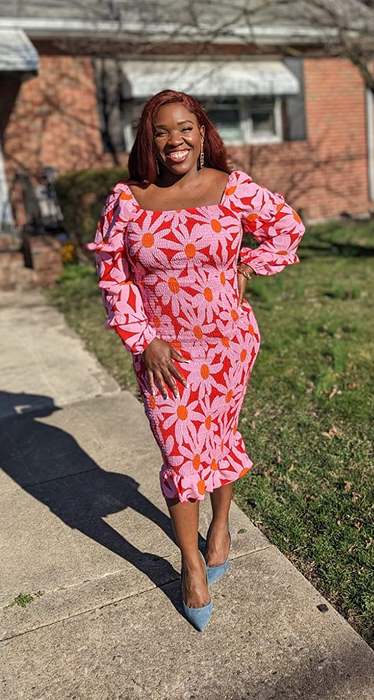 A reviewer wearing the pink floral smocked dress