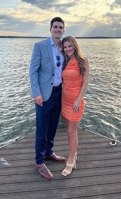 A reviewer in the orange one-shoulder dress, praising its unique design, vibrant color, and perfect fit for special occasions.