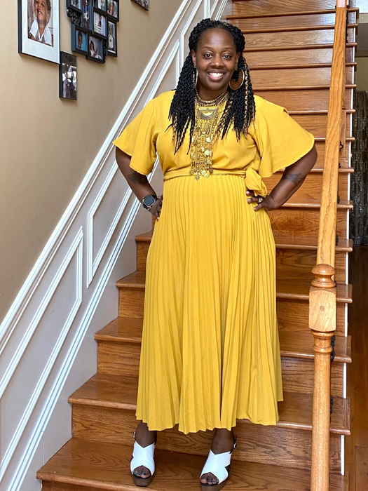 A reviewer wearing the yellow tie waist dress with short sleeves