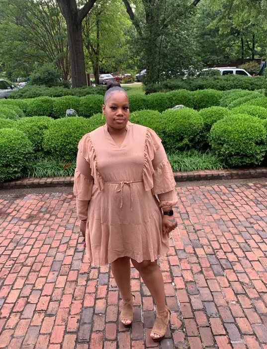 reviewer wearing a khaki-colored dress