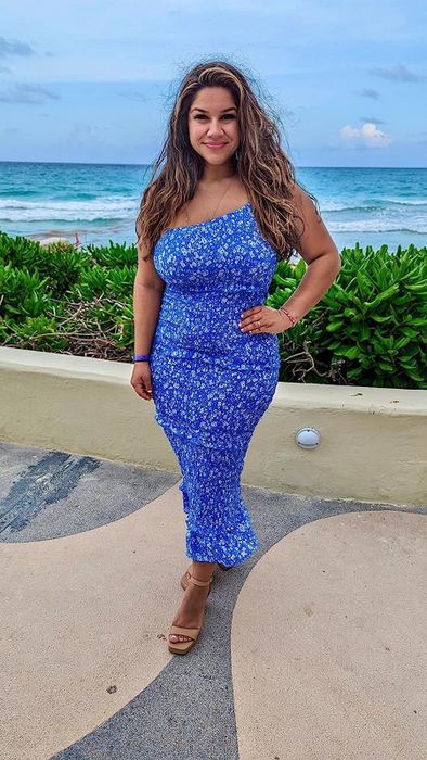 A reviewer in the blue floral long dress, praising its elegance, comfort, and perfect fit for formal occasions.