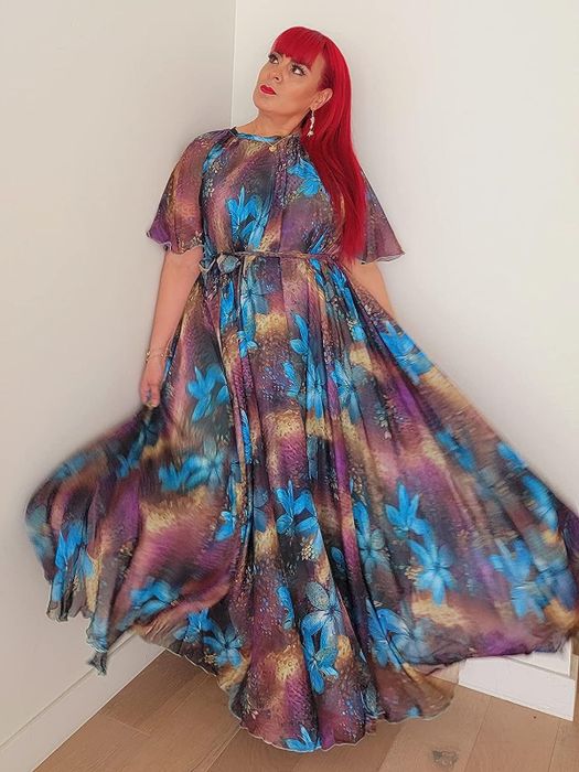 reviewer wearing a short-sleeve dress with a peacock print