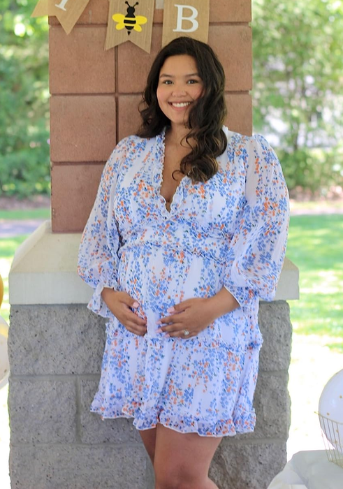 A reviewer showcasing the white and blue short dress