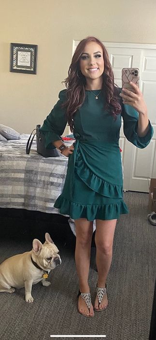A reviewer wearing the green dress with sandals