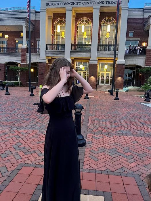 A reviewer in the black long dress, praising its timeless elegance and perfect fit for formal occasions.