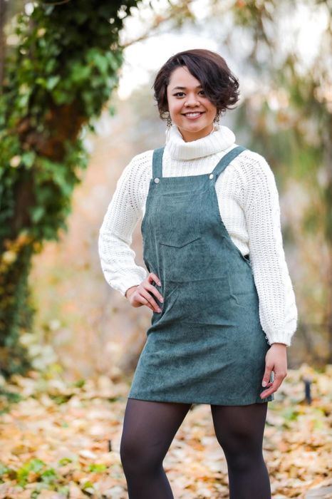 reviewer wearing the green pinafore with a white turtleneck underneath