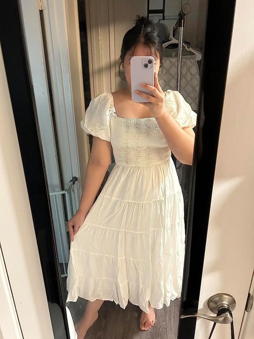 reviewer taking a mirror selfie in a white dress