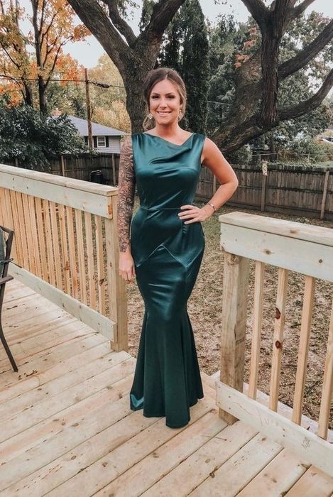 reviewer in a green silky cowl neck mermaid dress