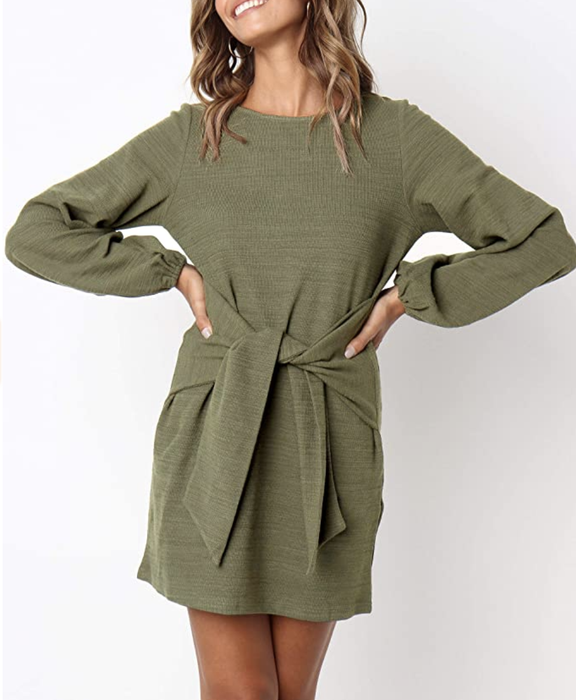 A model wearing a green long-sleeved dress with voluminous balloon sleeves and a stylish tie waist
