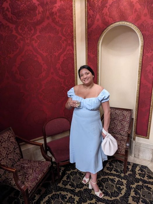 A reviewer in the light blue midi, praising its elegance, comfort, and suitability for various events.