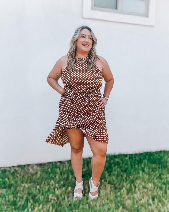 The reviewer is dressed in an elegant brown dress.