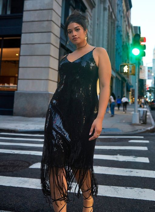 model wearing a midi dress featuring fringe and black sequins