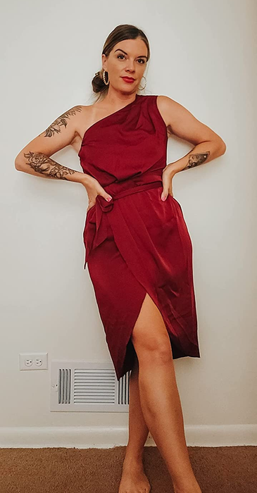 A reviewer showcasing the red satin dress
