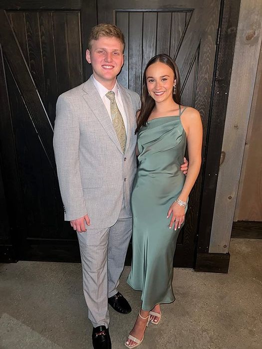 A reviewer wearing the green satin dress