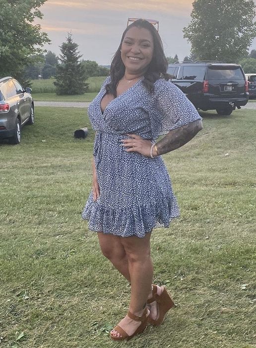 A reviewer wearing a short-sleeve V-neck belted mini dress in blue