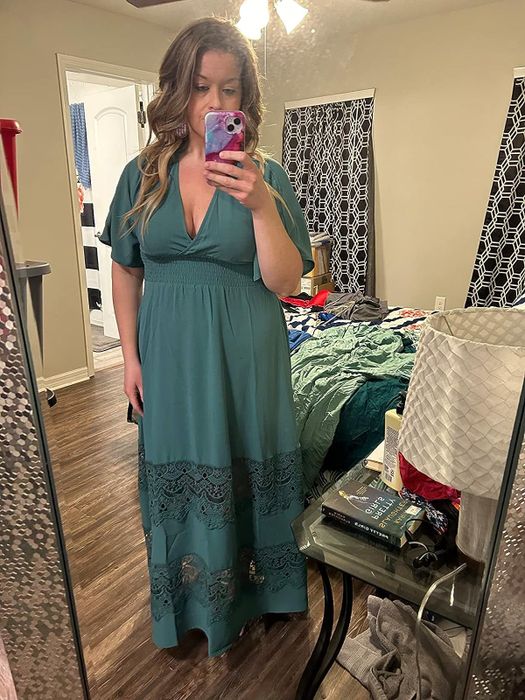 The reviewer is seen in a teal dress, captured in a mirror reflection.