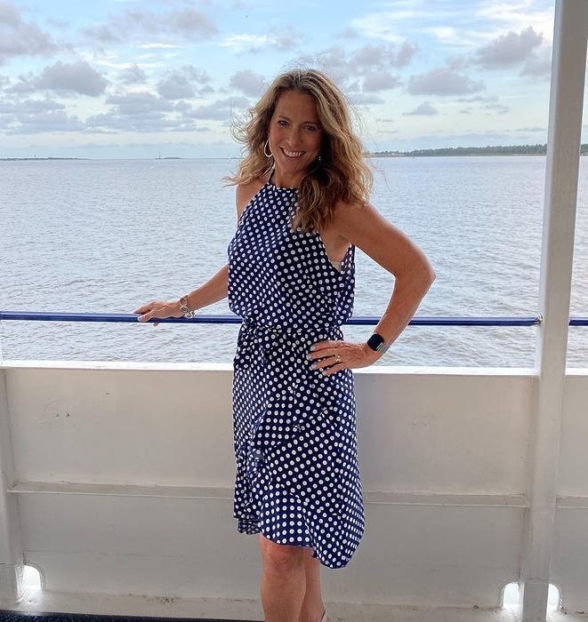 The reviewer is seen in a stylish navy dress.