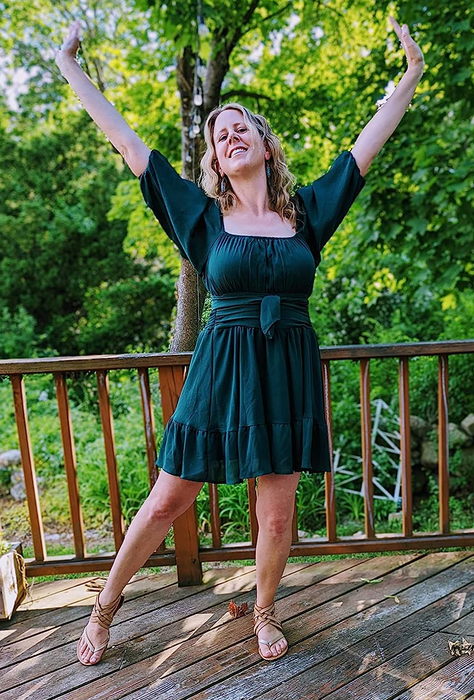 A reviewer wearing the green mini dress