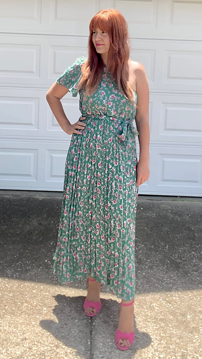 A reviewer modeling the dress in a lovely green floral pattern