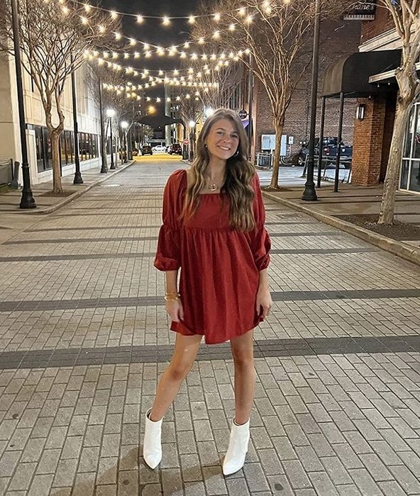 A reviewer modeling the same square-neck puff sleeve mini dress in a vibrant red