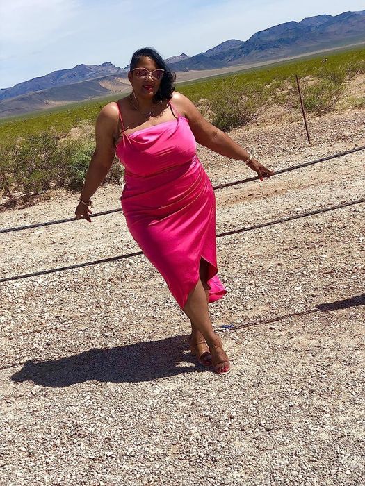 A reviewer wearing the pink slip midi dress paired with heels, highlighting its chic design and perfect fit for various occasions.