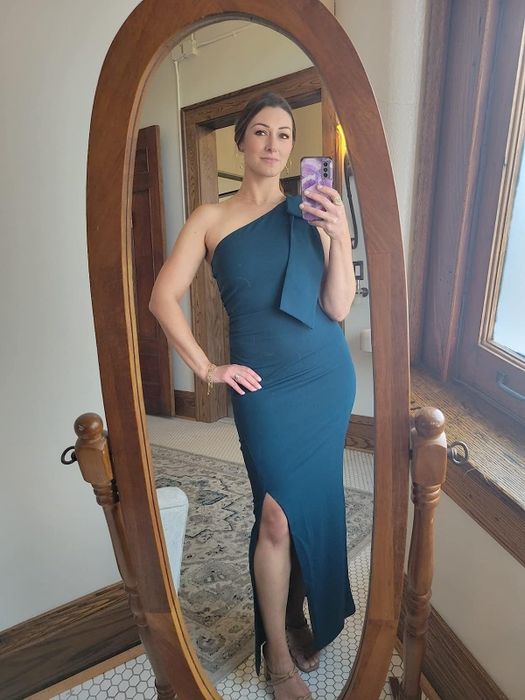 A reviewer wearing the blue one-shoulder gown, sharing their experience with its stunning design, perfect fit, and the compliments it garnered.