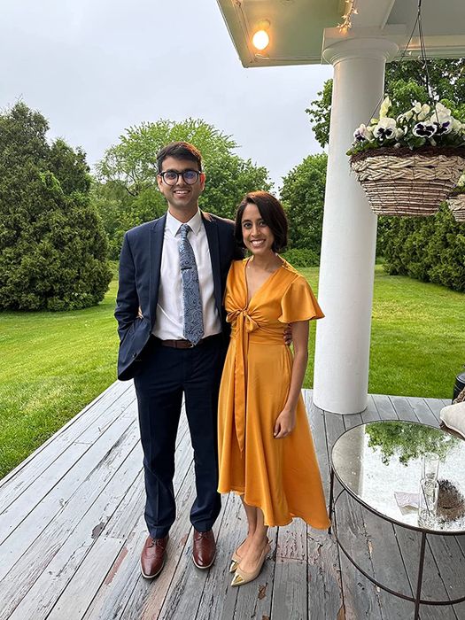 A reviewer showcasing the satin dress in a vibrant orange shade