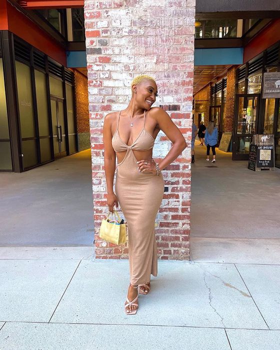 a reviewer showing off the dress in beige