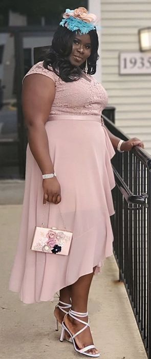 A reviewer showcasing the side view of the dress, highlighting its high-low hem