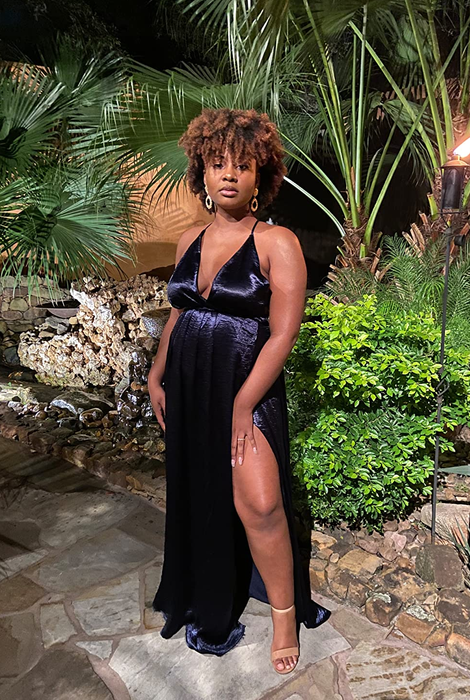 A reviewer rocking the black dress and highlighting the dramatic high slit