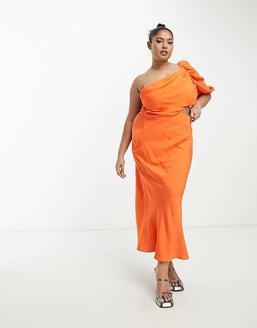 A model striking a pose in a vibrant orange maxi dress that turns heads