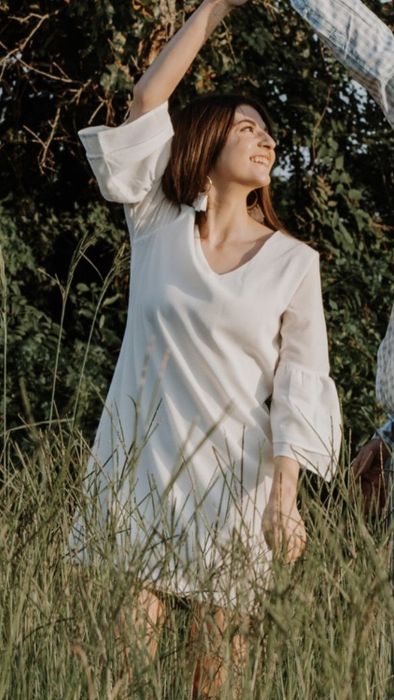 A reviewer wearing the white dress