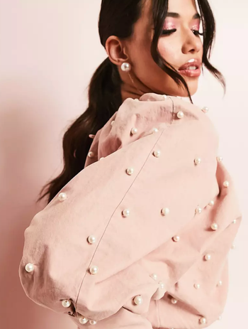 A close-up view of the sleeve highlighting the pearl embellishments