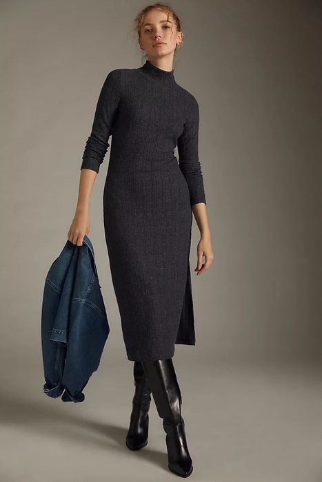 A model dressed in a grey sweater dress, paired with black boots and a denim jacket.