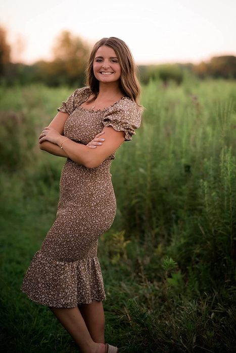 A reviewer in a brown and white dress
