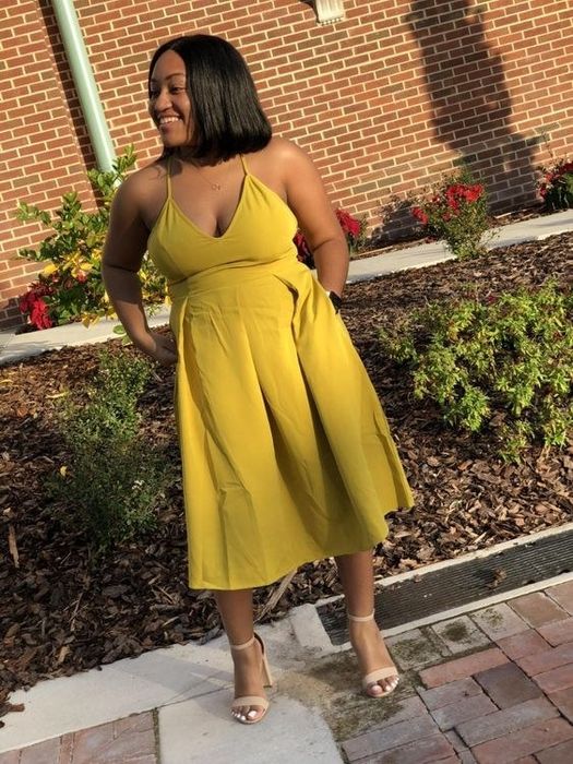 A reviewer modeling the yellow dress