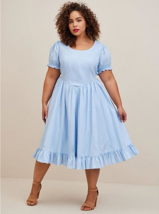 Model in a blue dress and brown sandals