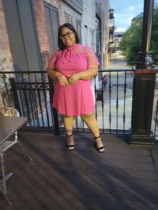 A reviewer dressed in a vibrant pink outfit