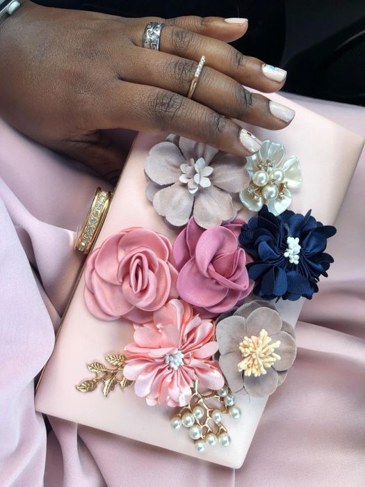 a close-up view of the clutch’s textured flowers and gold embellishments