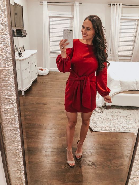 A reviewer wearing the red dress