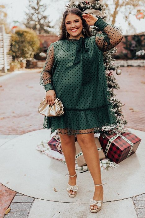 A model confidently poses in a green outfit, showcasing its bold elegance.