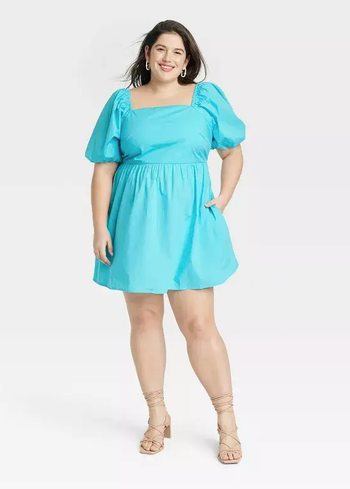 Another model wearing a vibrant blue dress.