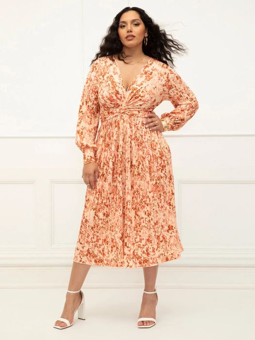 Model in an orange and white dress paired with white shoes