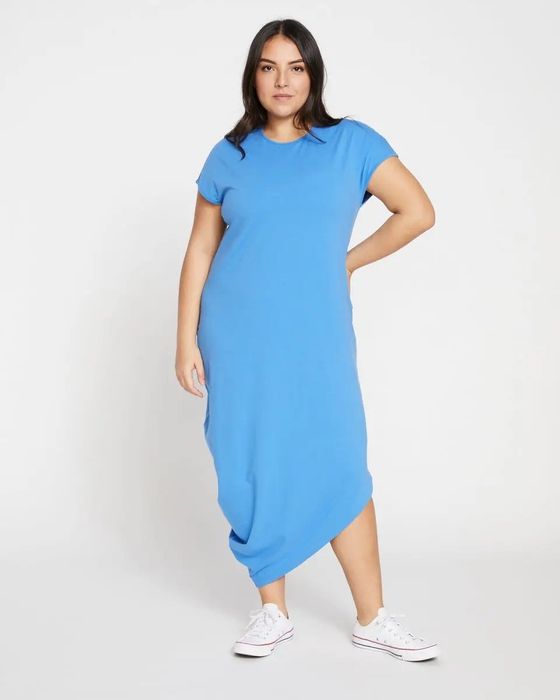 Model wearing a blue dress paired with white shoes